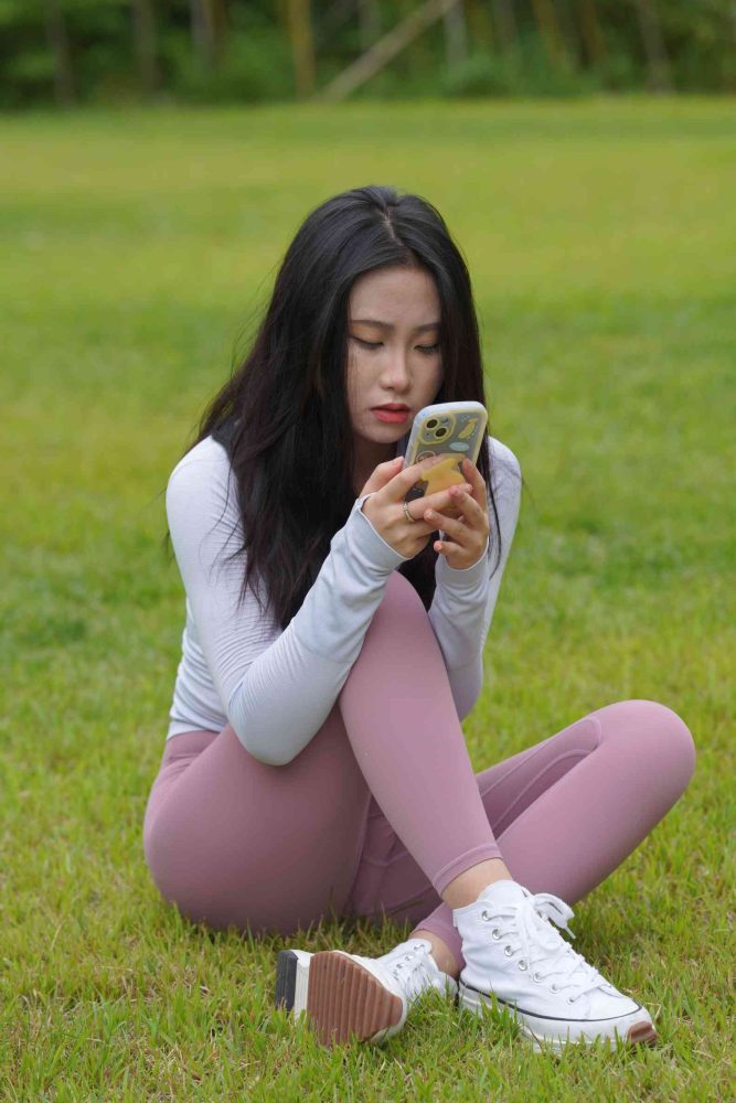 坐在草地玩手机的瑜伽姑娘【733P】04012-多米街拍